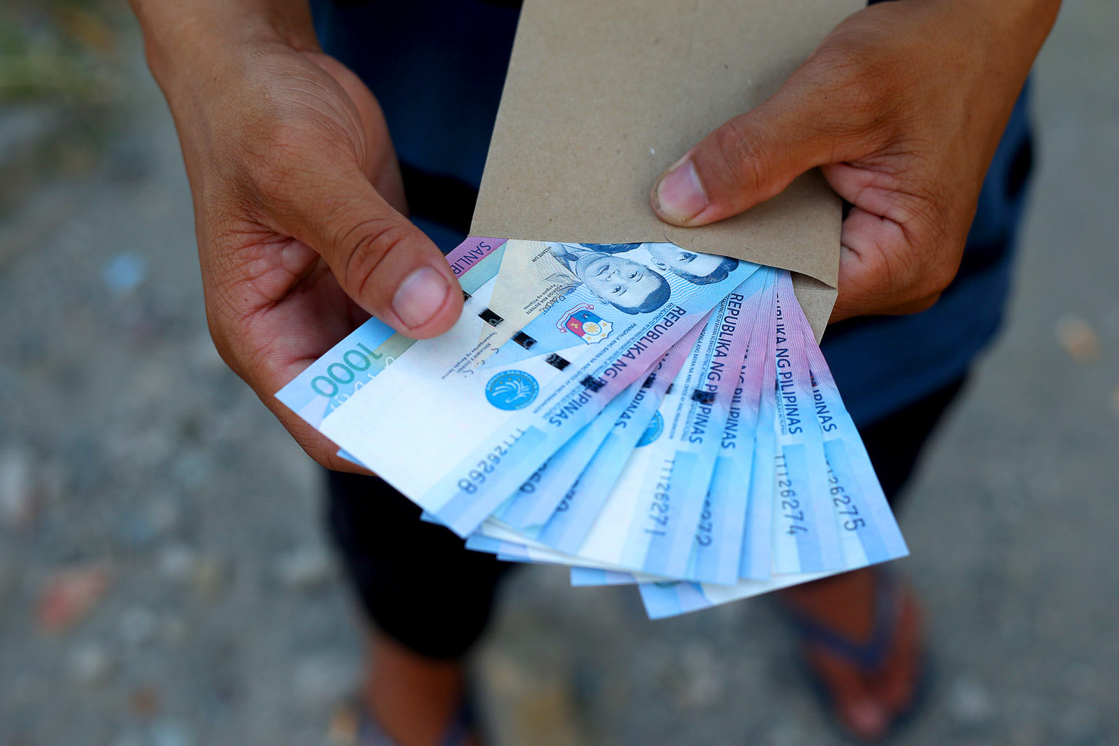 CASH. A beneficiary receives P8,000 cash aid from the government's Emergency Subsidy Program on the eve of the payout deadline, May 6, 2020. Photo by Inoue Jaena/Rappler 