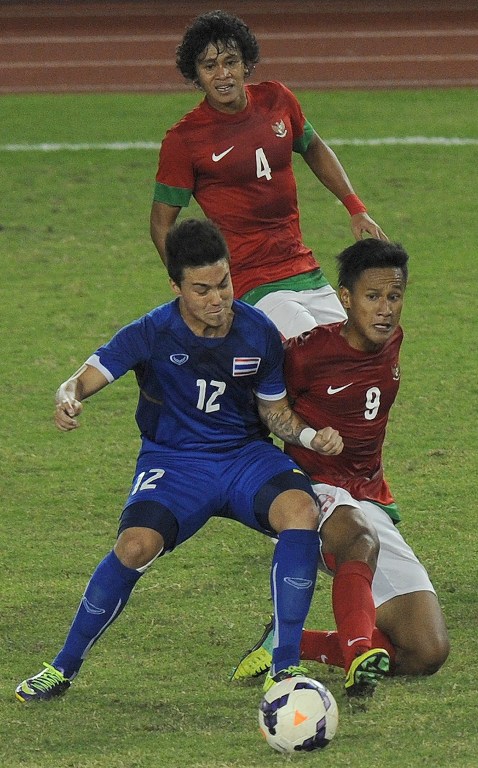 Yandi Sofyan (kanan) saat berebut bola dengan pemain Thailand dalam pertandingan final SEA Games pada 21 Desember 2013. Foto oleh Soe Than Win/AFP  