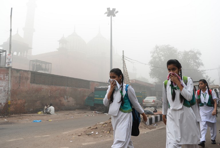 POLLUTED. File photo of Indian schoolchildren covering their faces as they walk to school amid heavy smog in New Delhi on November 8, 2017. Photo by Sajjad Hussaon/AFP 
 