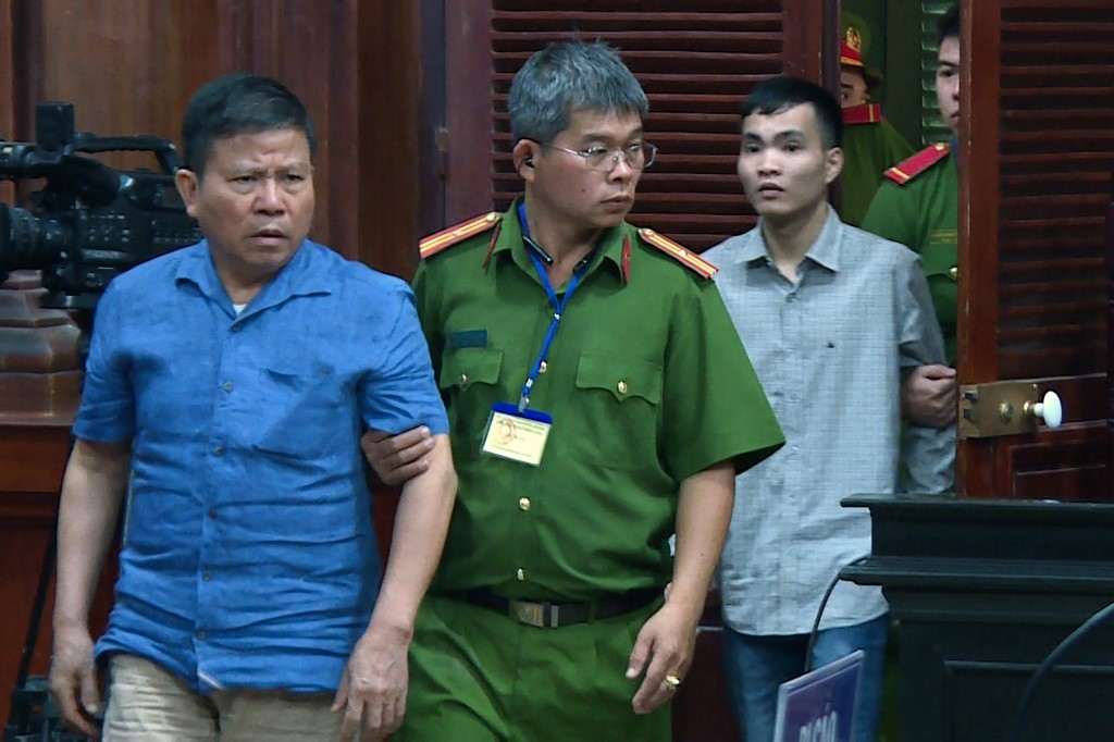 CHAU VAN KHAM. This picture from the Vietnam News Agency taken and released on November 11, 2019 shows Australian citizen Chau Van Kham (L) escorted for trial in Ho Chi Minh City. Photo by Vietnam News Agency/AFP 