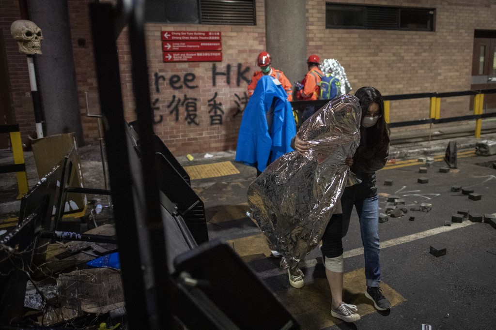 NEEDING WARMTH. Protesters covered with blankets and thermal blankets are helped out from the campus by medics inside the Hong Kong Polytechnic University after being barricaded inside for days in the Hung Hom district of Hong Kong on November 20, 2019. Photo by Nicolas Asfouri/AFP 