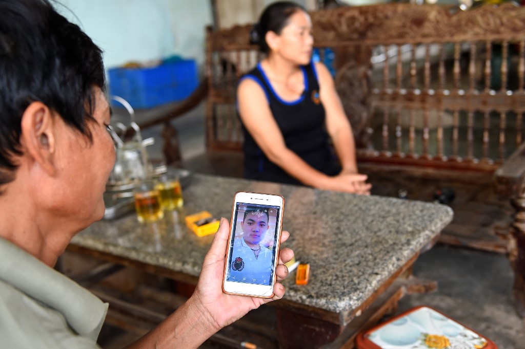 CONFIRMED. Hoang Lanh, father of 18-year old Hoang Van Tiep who is feared to be among the 39 people found dead in a truck in Britain, looks at his son's photograph on his phone at their house in Dien Thinh commune of Vietnam's Nghe An province on October 28, 2019. File photo by Nhac Nguyen/AFP 
