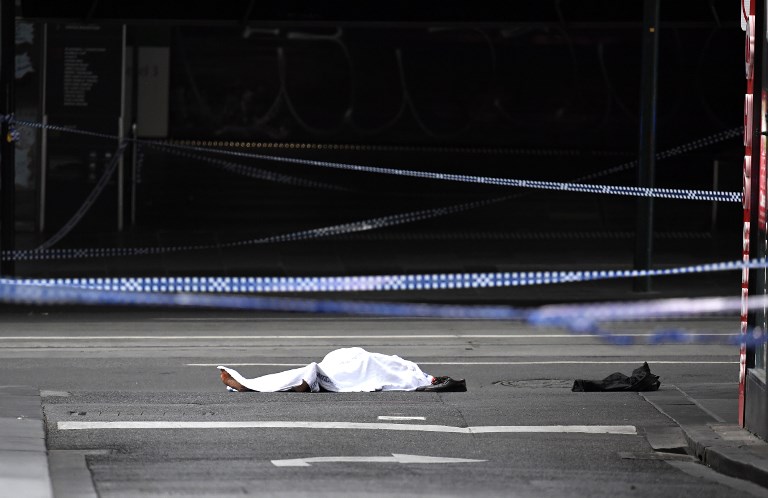 RUSH HOUR. A body is seen under a white sheet at the scene following a rush hour stabbing incident in Melbourne on November 9, 2018. Photo by William West/AFP  