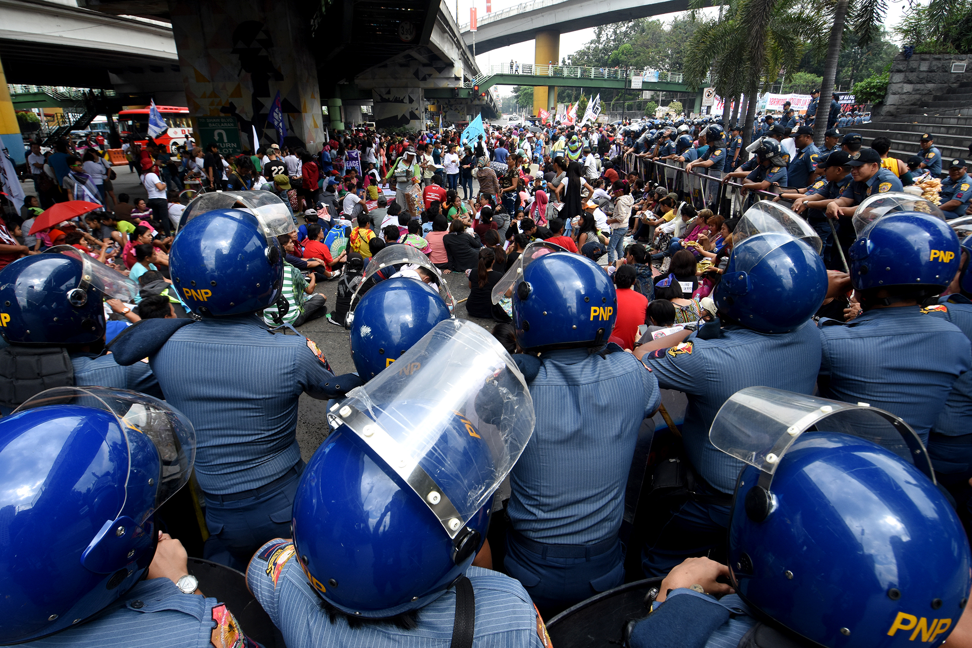 POLICE. Activists are watched by police as they rally in front of the EDSA Shrine. Photo by Angie de Silva/Rappler  