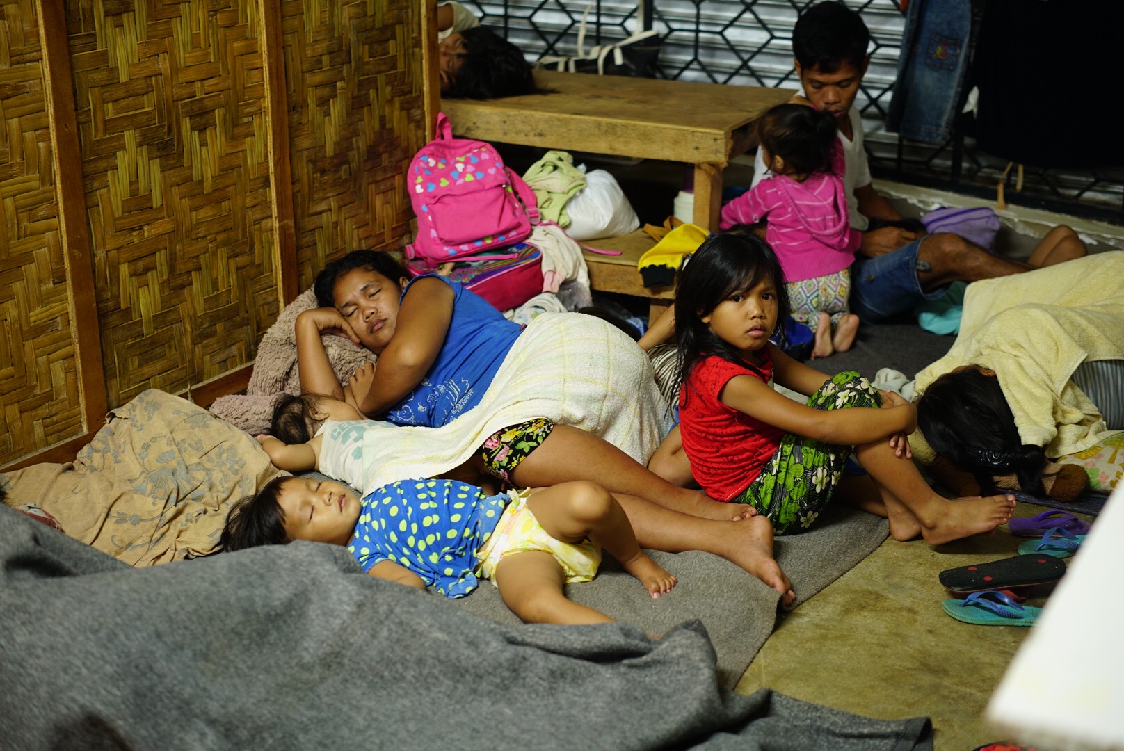 AFFECTED FAMILIES. Rochel Waniwan, 34, cradles her 3-month daughter as she spends her first storm in the Cogon evacuation center in Guiuan, Eastern Samar, as residents brace for Urdujaâs landfall, Thursday night, December 14. Photo by Martin San Diego/Rappler 