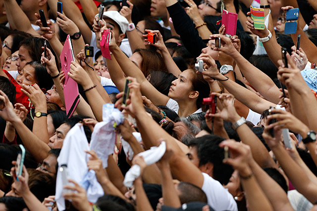 MOBILE POWER. Filipinos take pictures of the Pope Francis while passing by a street near the Manila Cathedral on January 16, 2015. File photo by Francis Malasig / EPA