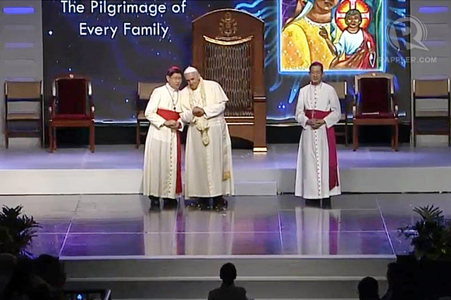 Pope Francis (C) talks to Manila Archbishop Luis Antonio Cardinal Tagle (L) during the meeting with families at the Mall of Asia Arena, January 16, 2015. Rappler photo