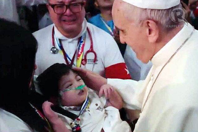 Pope Francis blesses Brandon Emmanuel Lao during his meeting with families at the Mall of Asia Area on January 17, 2015. Rappler photo 