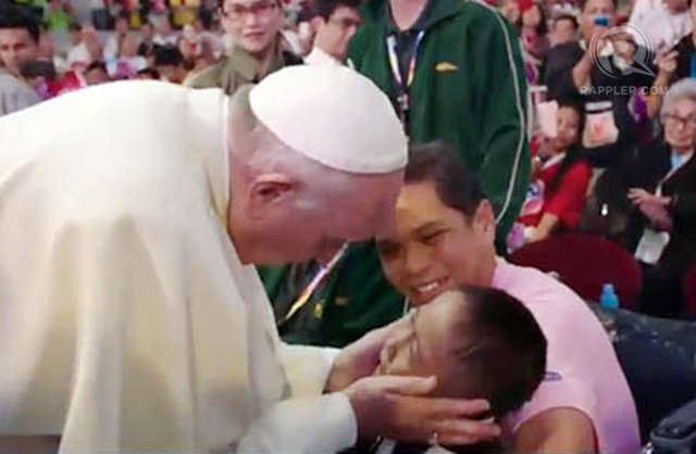 Pope Francis touches a child before the start of the meeting with families at the Mall of Asia Arena, January 16, 2015. Rappler photo