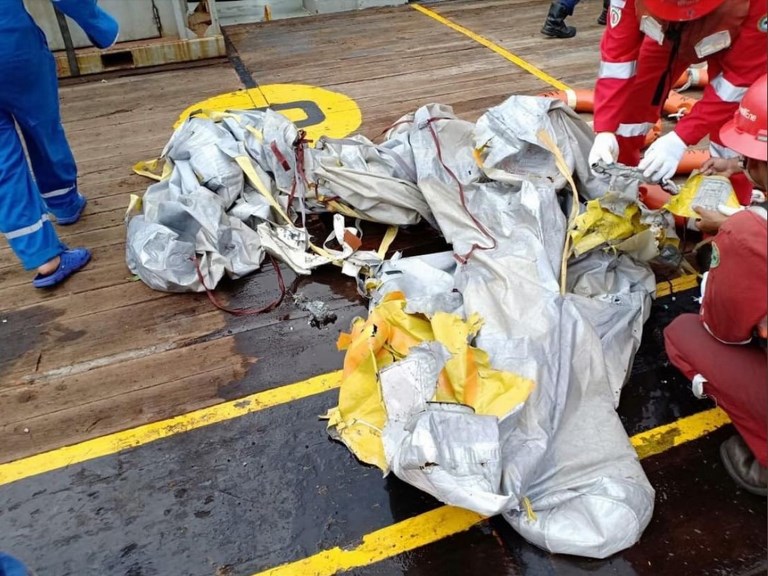 This handout photo taken by Pertamina Hulu Energy and released on October 29, 2018 via the Twitter account of Sutopo Purwo Nugroho from Indonesia's National Disaster Mitigation Agency shows personnel looking at items believed to be from the wreckage of the Lion Air flight JT 610, recovered off the coast of Indonesia's Java island after the Boeing crashed into the sea. Photo handout from Pertamina Hulu Energy via National Disaster Mitigation Agency/AFP 