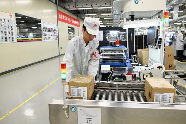 HUAWEI. An employee works on a mobile phone production line at a Huawei production base during a media tour in Dongguan, China's Guangdong province on March 6, 2019. Photo by Wang Zhao/AFP 