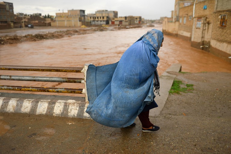 MASSIVE FLOODING. In this photo taken on March 29, 2019, an Afghan woman crosses a bridge following flash floods in Herat province. Photo by Hoshang Hashimi/AFP 