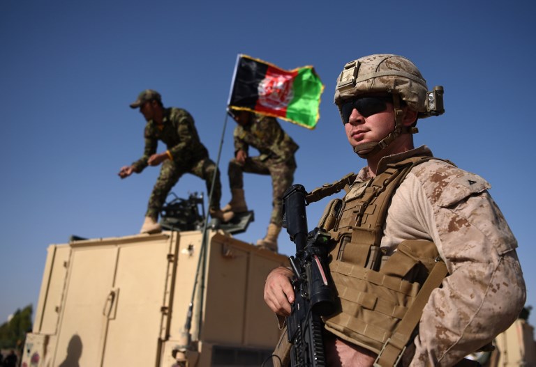 SHORAB CAMP. In this photograph taken on August 28, 2017, a US Marine looks on as Afghan National Army soldiers raise the Afghan National flag on an armed vehicle during a training exercise to deal with IEDs (improvised explosive devices) at the Shorab Military Camp in Lashkar Gah in Helmand province. File photo by Wakil Kohsar/AFP 