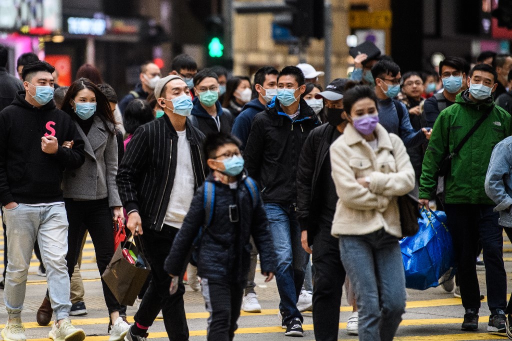 CORONAVIRUS OUTBREAK. Pedestrians wearing face masks cross a road during the Lunar New public holiday in Hong Kong on January 27, 2020, as a preventative measure following a coronavirus outbreak. Photo by Anthony Wallace/AFP 