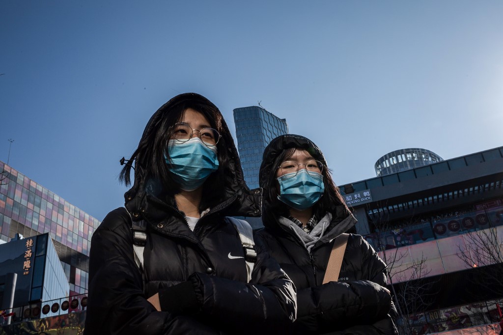 HOTLINE. People wear protective masks as they walk outside a shopping mall in Beijing on January 23, 2020. File photo by Nicolas Asfouri/AFP 