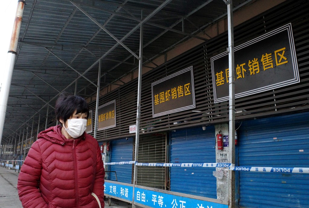 CLOSED. In this file photograph taken on January 12, 2020 a woman walks in front of the closed Huanan wholesale seafood market, where health authorities say a man who died from a respiratory illness had purchased goods from, in the city of Wuhan, Hubei province. Photo by Noel Celis/AFP 