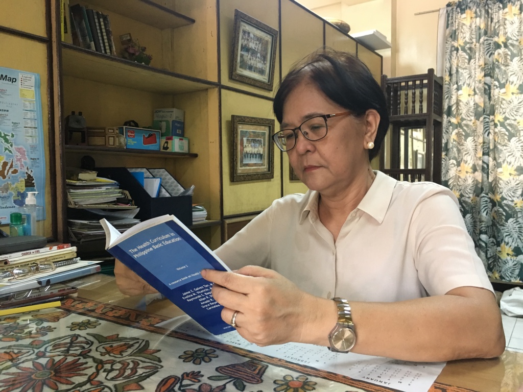 THE GUIDE. Arellano High School's MAPEH head teacher Carol Manalaysay reads the health curriculum provided to them by DepEd. Photo by Mara Cepeda/Rappler   