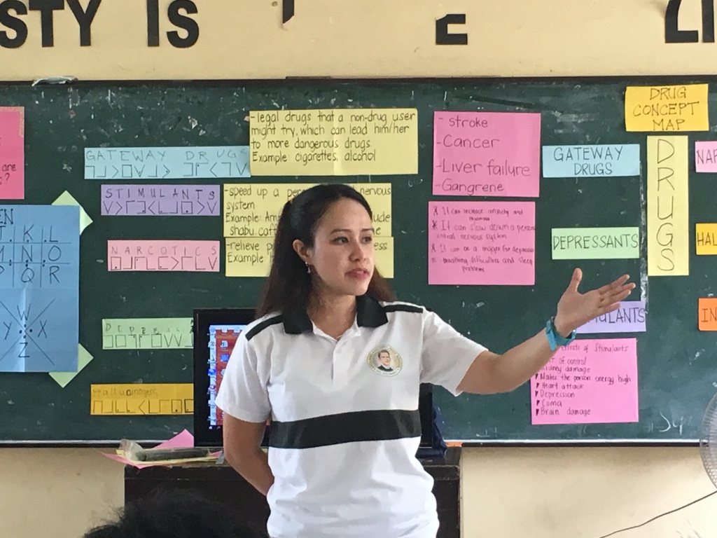 PAPER MEETS SCREEN. Health teacher Leah Olmos discusses the dangers of drug abuse with the help of cartolinas and a television screen. Photo by Mara Cepeda/Rappler  
