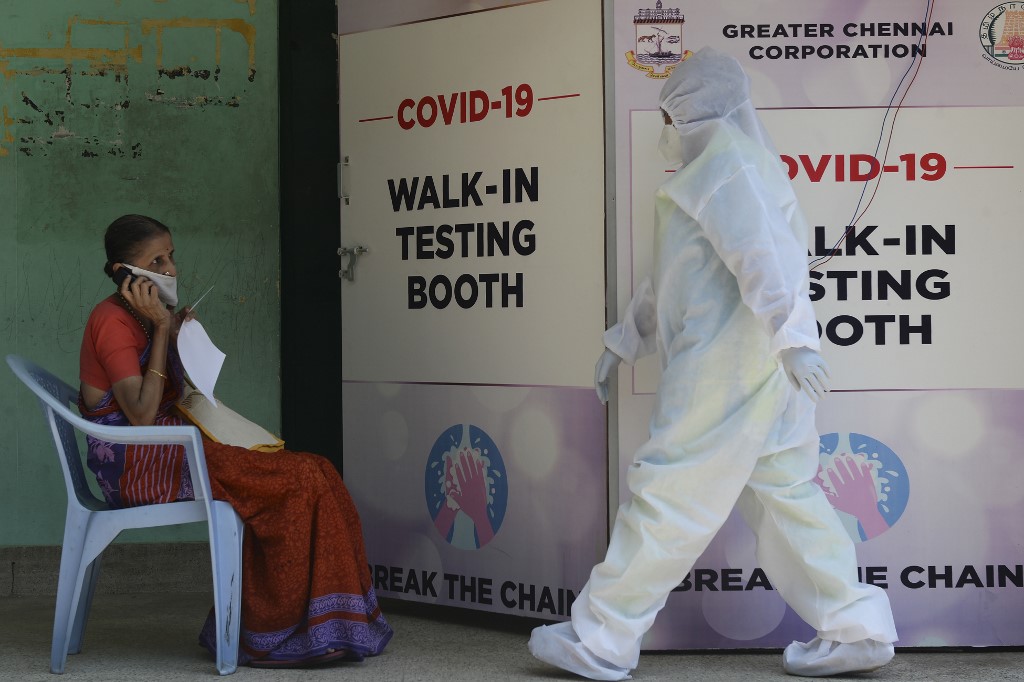 INDIA AND THE CORONAVIRUS. A medical technician wearing personal protective equipment (PPE) walks past as a woman waits to give a sample at a COVID-19 testing center during a government-imposed nationwide lockdown as a preventive measure against the COVID-19 coronavirus in Chennai on June 26, 2020. File Photo by Arun Sankar/AFP 
