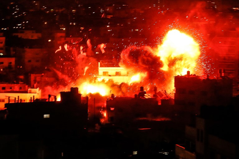 GREAT BALLS OF FIRE. A picture taken on November 12, 2018, shows a ball of fire above the building housing the Hamas-run television station al-Aqsa TV in the Gaza Strip during an Israeli air strike. Photo by Mahmud Hams/AFP  