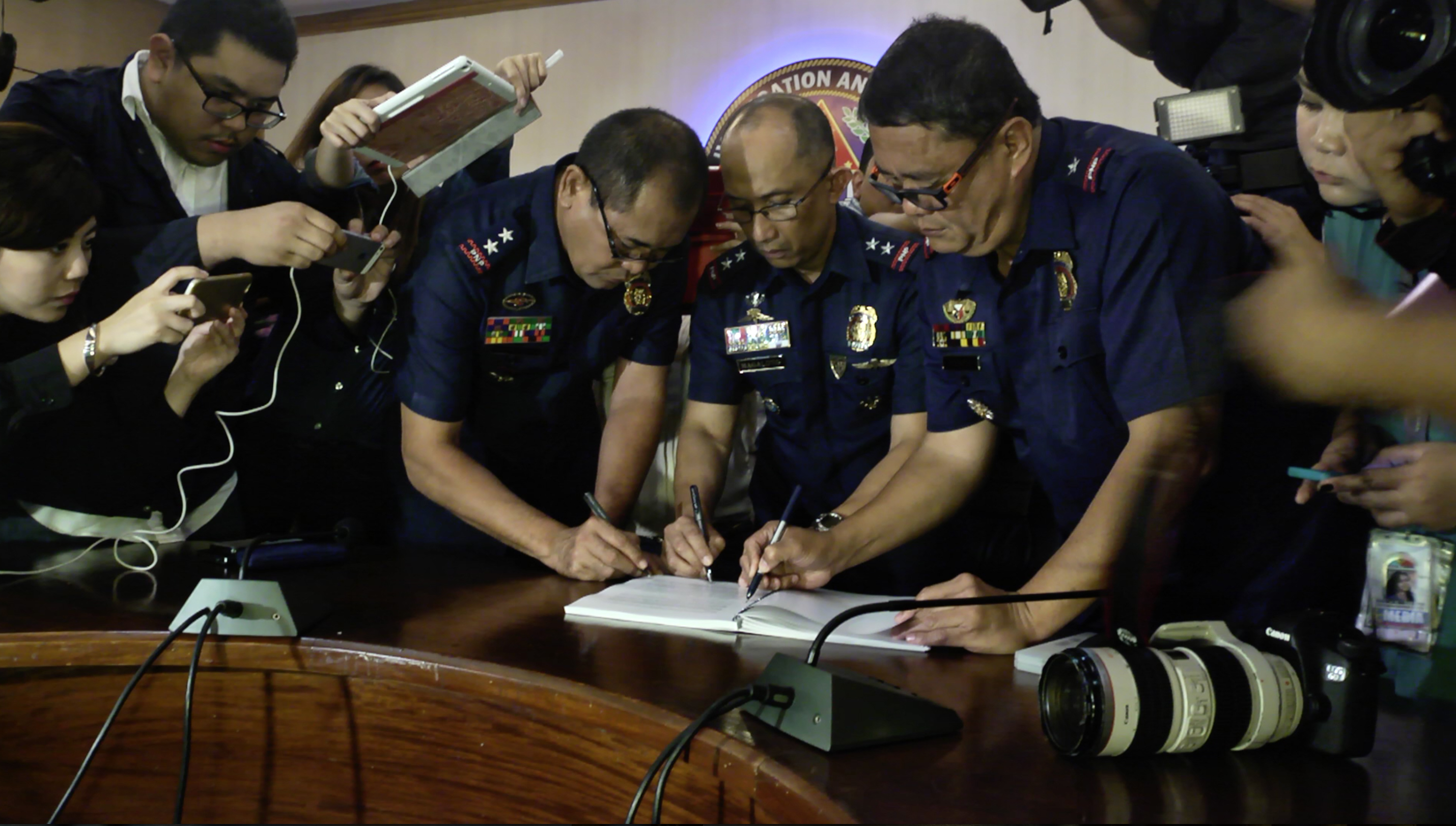 JOB IS DONE. Members of the police Board of Inquiry sign the final report they submitted to the PNP OIC chief. 