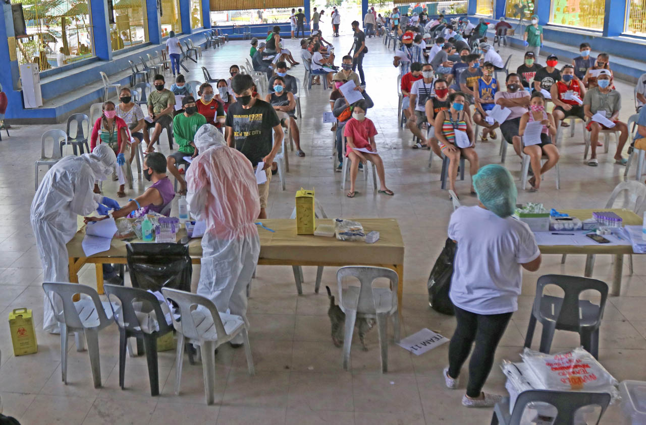 CURBING SPREAD IN CEBU. Residents in Barangay Mabolo, Cebu City undergo blood extraction for rapid testing. Photo by Gelo Litonjua/Rappler 