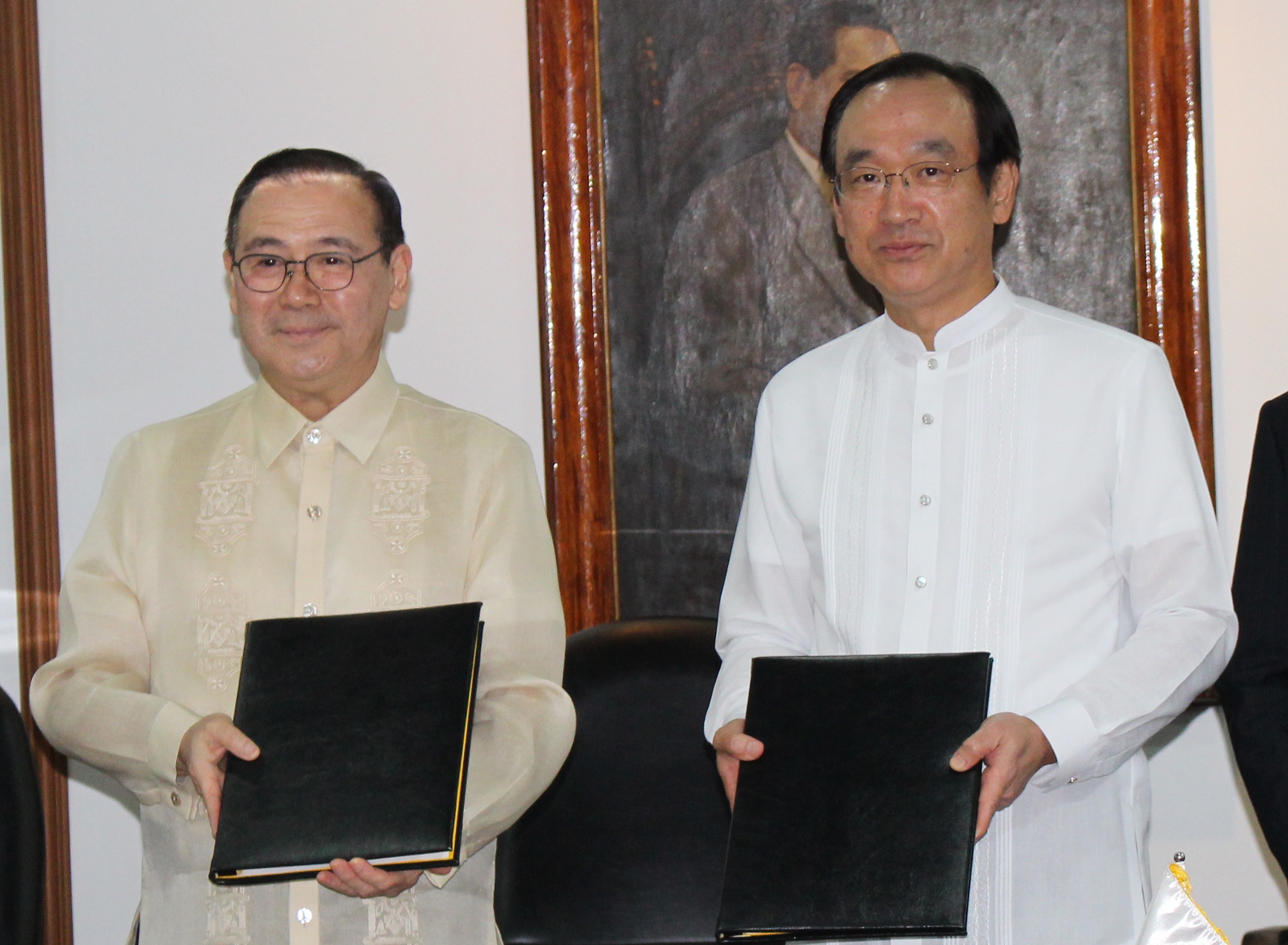 SIGNING. Philippine Foreign Secretary Teodoro Locsin Jr (left) and Japanese Ambassador to the Philippines Koji Haneda exchange notes on the MRT3 rehabilitation loan deal. Photo from Embassy of Japan 