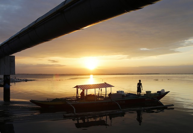 Filipino fishermen maneuver their boat as the sun sets in Manila Bay, Philippines, April 1, 2016. Francis R Malasig/EPA 
