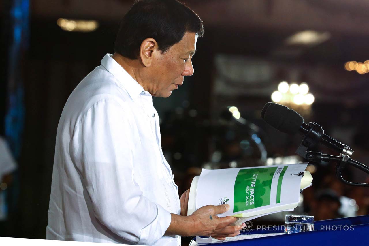 FIGHTING DRUGS. President Rodrigo Duterte skims through the report of the United Nations Office on Drugs and Crime (UNODC) as he explains the effects of various illegal drugs while delivering his speech on December 5, 2017. Malacañang photo  