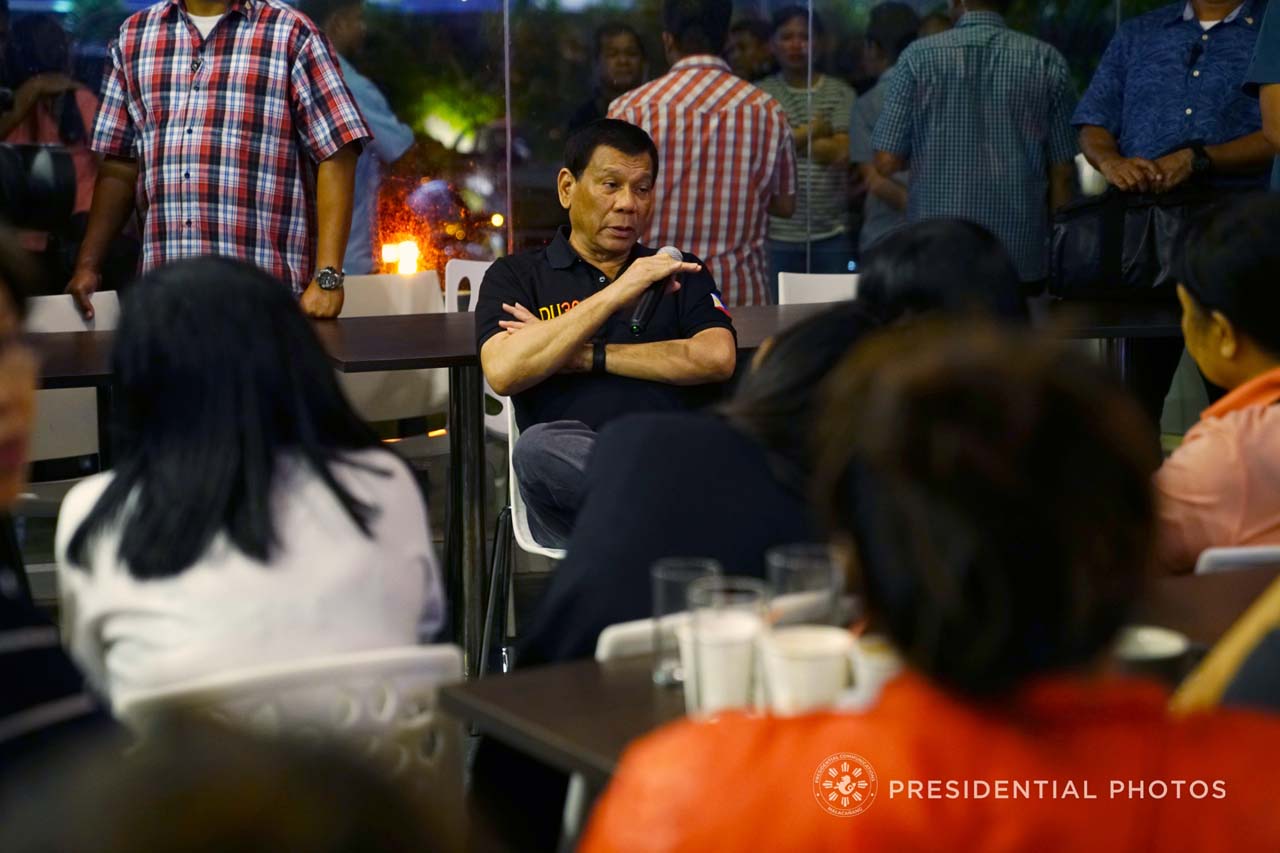 COMFORTING RELATIVES. President Rodrigo Duterte talks to the families of victims who were trapped inside the NCCC Mall in Davao City, where a fire raged on December 23, 2017. Malacañang photo  