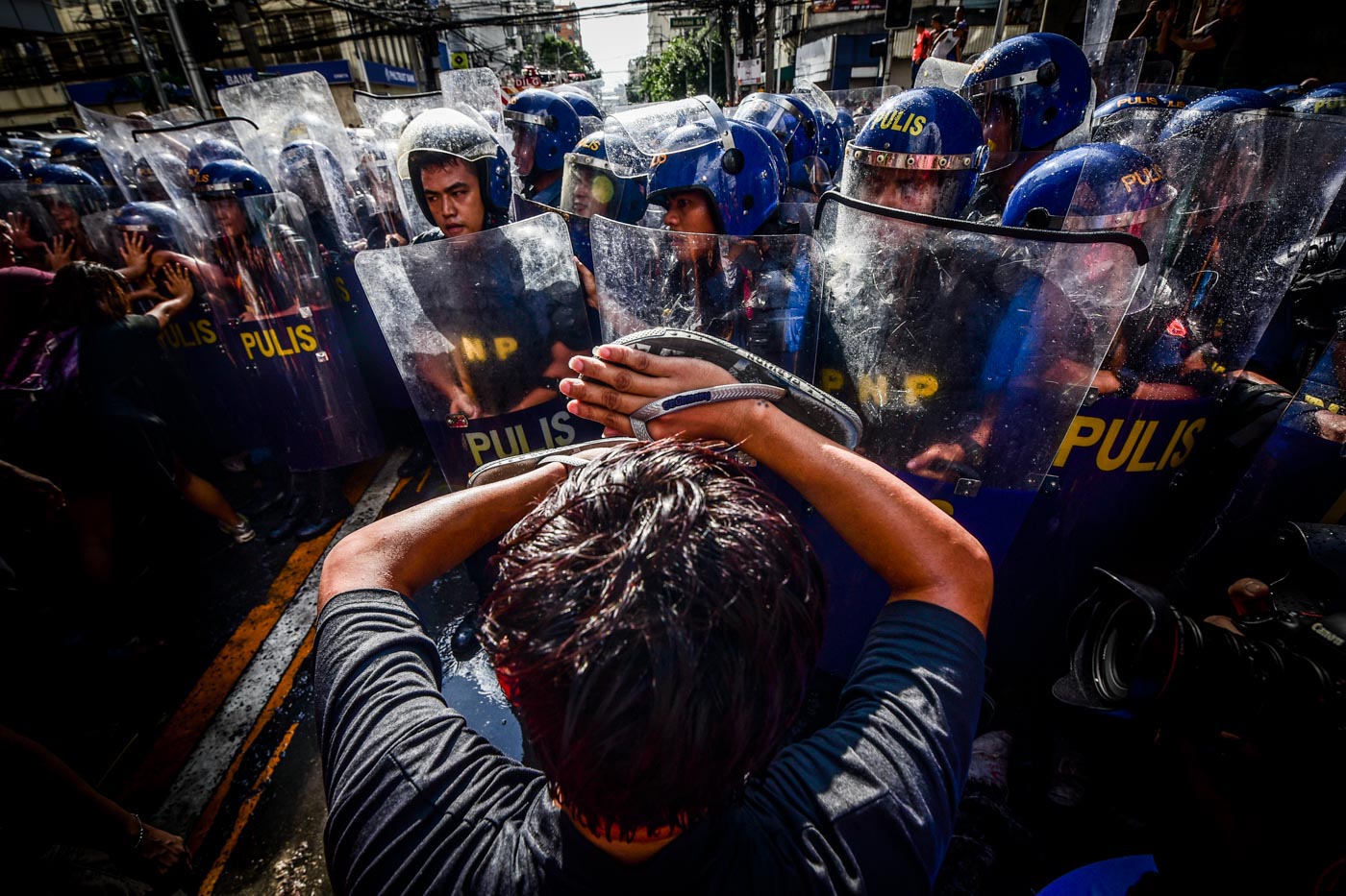 FACE-OFF. Protesters confront cops along Bocobo Street near the US embassy to protest during the first day of the 31st ASEAN Summit. Photo by Alecs Ongcal/Rappler 