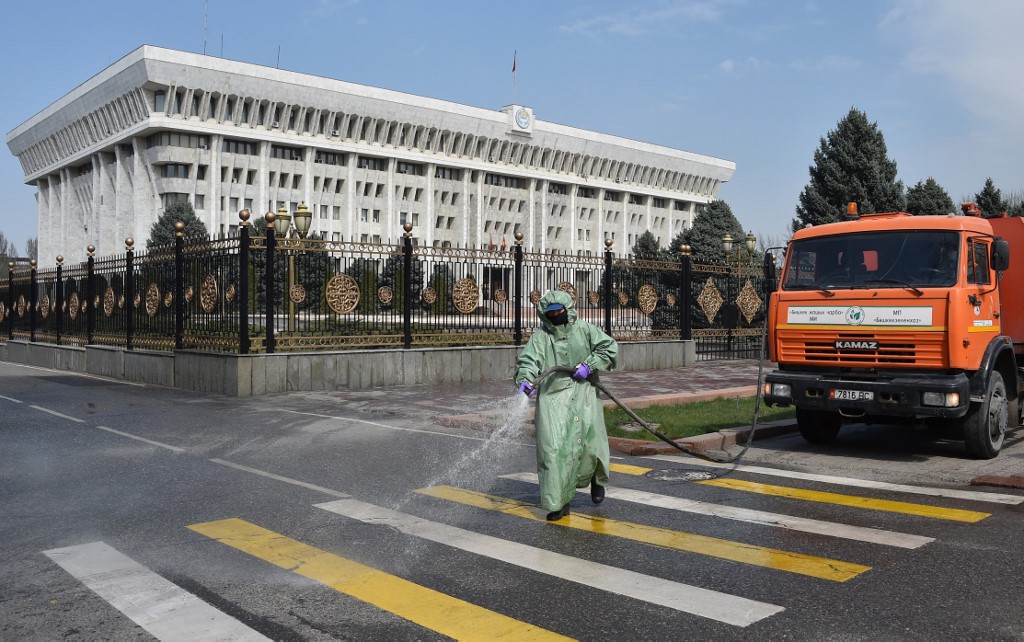 BISHKEK. A municipal worker disinfects a street in front of the Parliament as a measure against the COVID-19 coronavirus pandemic in Bishkek on March 26, 2020. Photo by Vyacheslav Oseledko/AFP 