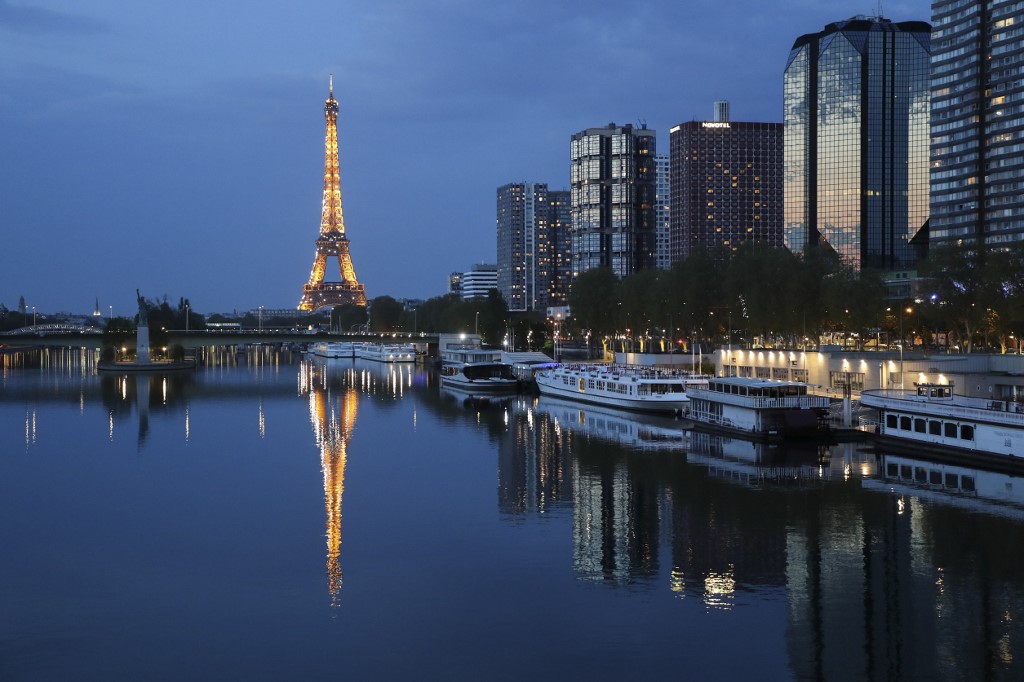 LOCKDOWN. General view of the illuminated Eiffel Tower reflected on the Seine river in Paris at night, on April 12, 2020, during a strict lockdown in France to stop the spread of COVID-19. File photo by Ludovic Marin/AFP 