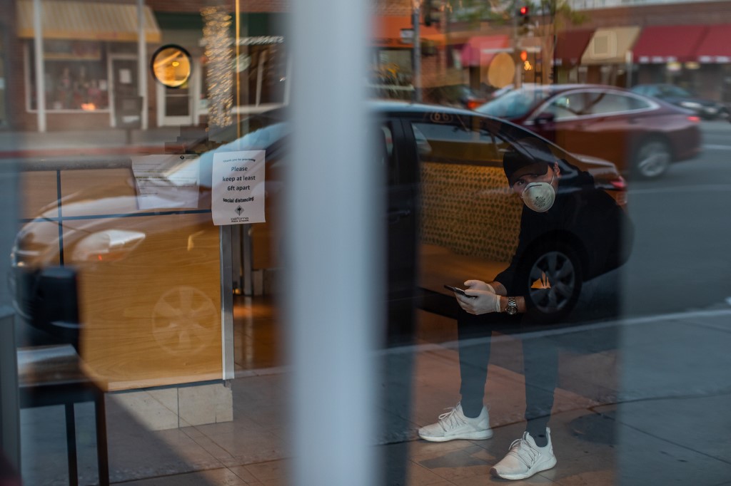 WAITING. Musician Lucas Goes wears a mask and gloves as he waits to pick up food for a delivery app in Beverly Hills, California, after losing his job during the novel coronavirus outbreak. Photo by Apu Gomes/AFP 