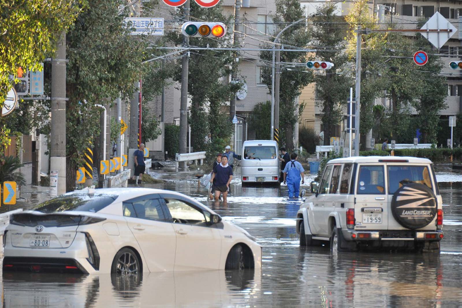 Local residents walk on a flooded street in the aftermath of Typhoon Hagibis in Kawasaki on October 13, 2019. Photo by Jiji Press/AFP 