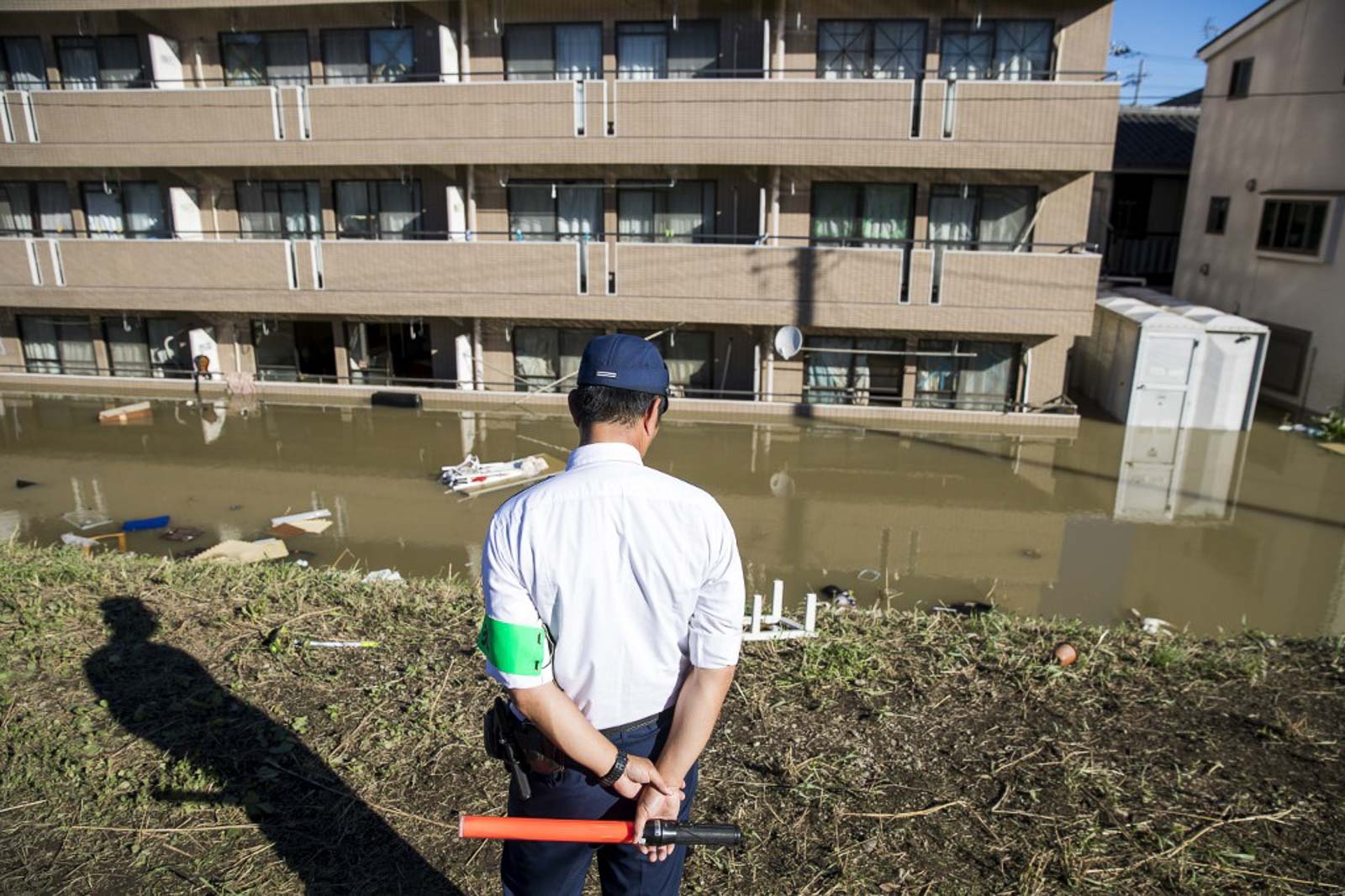 Police inspect damage along an embankment beside a flooded residential block in the aftermath of Typhoon Hagibis in Kawasaki on October 13, 2019. Photo by Odd Aandersen/AFP 