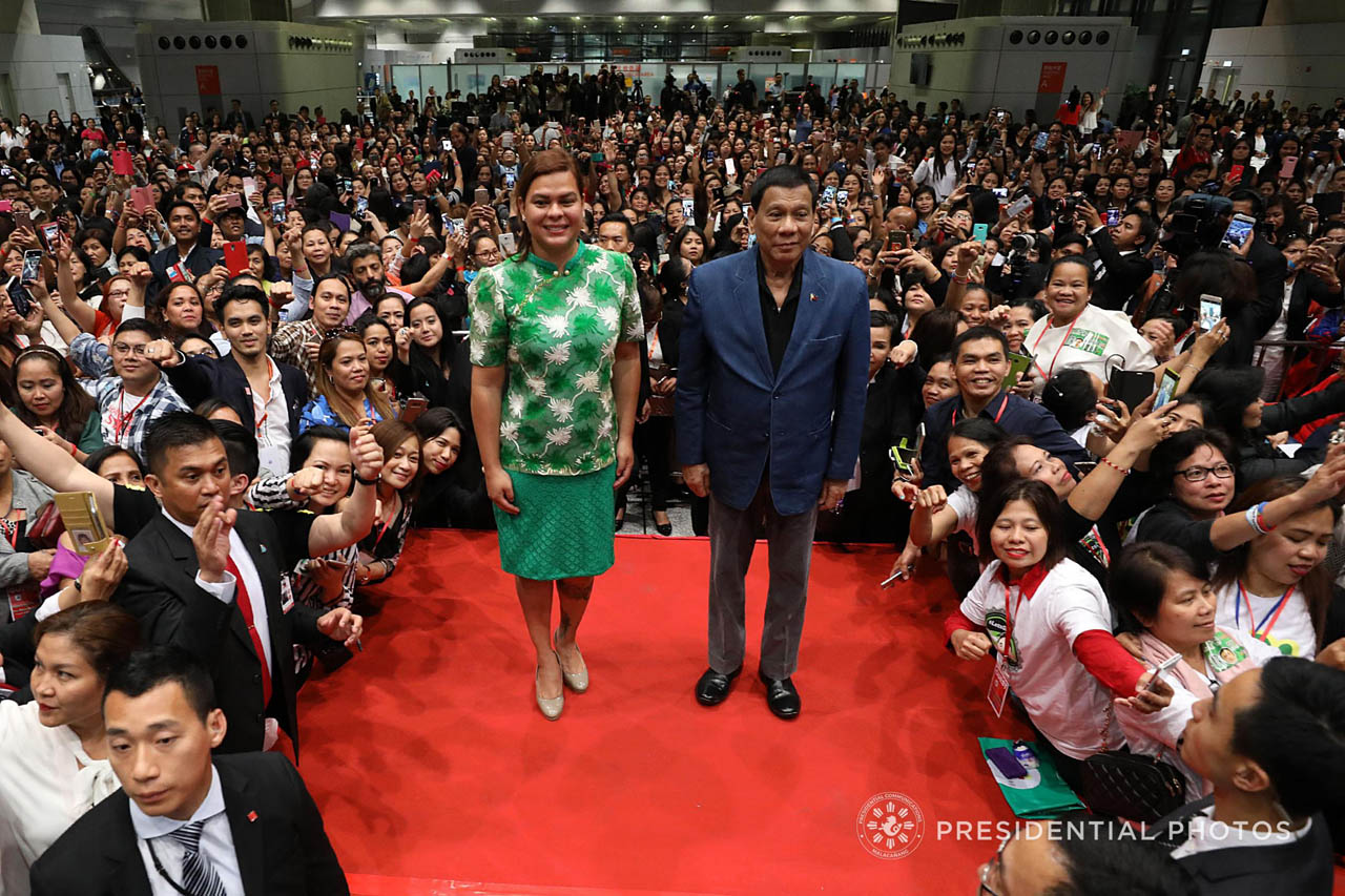 President Rodrigo Roa Duterte and Davao City Mayor Sara Duterte-Carpio pose for a photo while they are surrounded by supporters during the Presidentâs meeting with the Filipino community at the Kai Tak Cruise Terminal in Hong Kong on April 12, 2018. SIMEON CELI JR./PRESIDENTIAL PHOTO 