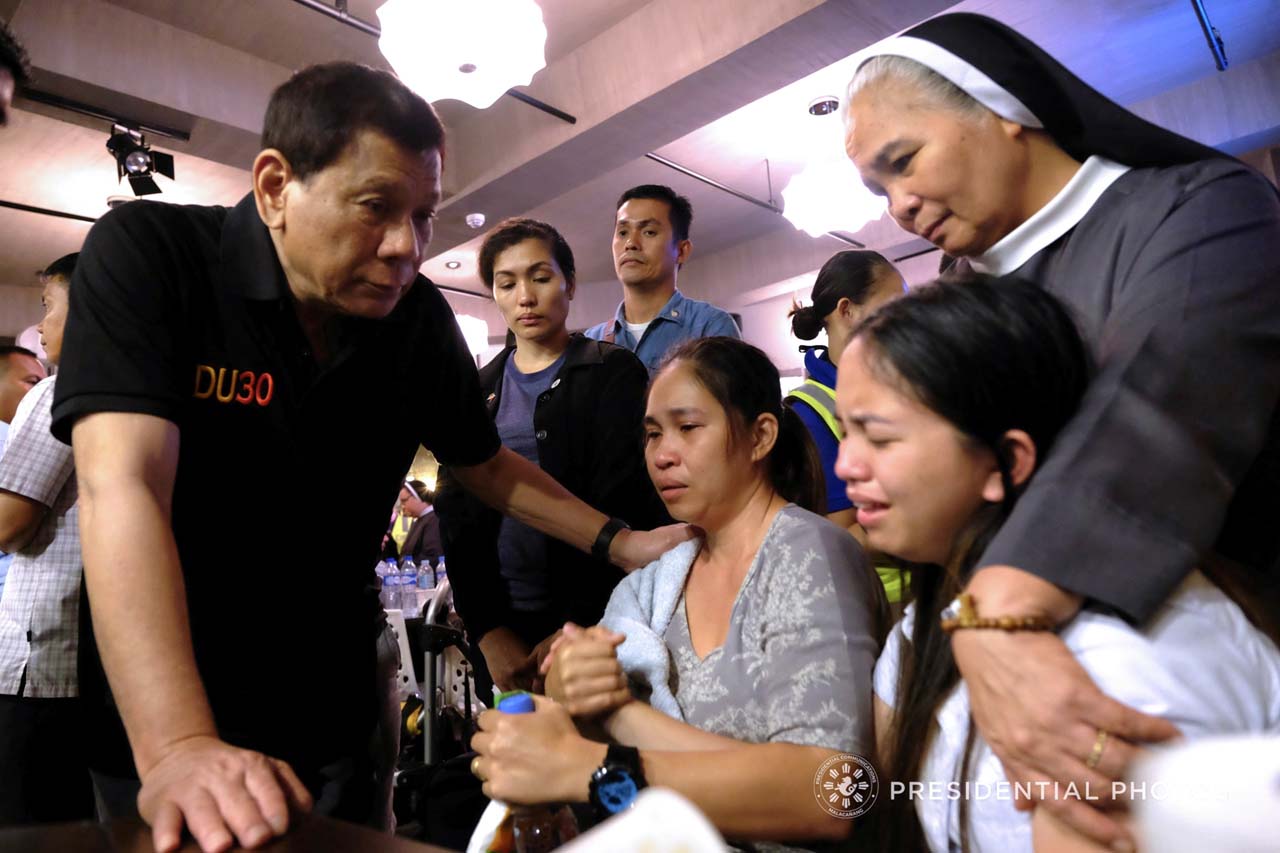 SORROW. President Rodrigo Duterte consoles the relatives of one of the victims who were trapped inside the NCCC Mall Davao upon hearing the news that their loved ones may have zero chance of survival as the fire inside the mall continues to rage as of dawn of December 24, 2017. KIWI BULACLAC/PRESIDENTIAL PHOTO
 