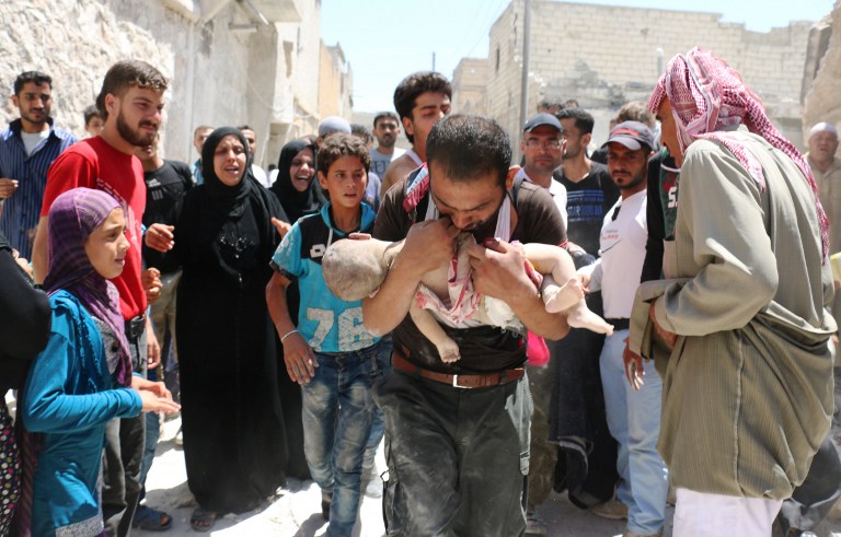 A Syrian man holds the body of his child after it was taken from under the rubble of destroyed buildings following a reported air strike on the rebel-held neighborhood of al-Marjah in the northern city of Aleppo, on July 24, 2016. Ameer Alhalbi/AFP 