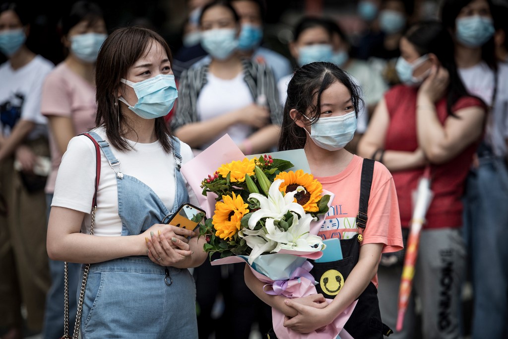 ENTRANCE EXAMS. A girl holds a bouquet of flowers as she waits for her sister to finish the National College Entrance Examination (NCEE), known as "gaokao", outside a school in Wuhan in China's central Hubei province on July 8, 2020. Photo by AFP 
