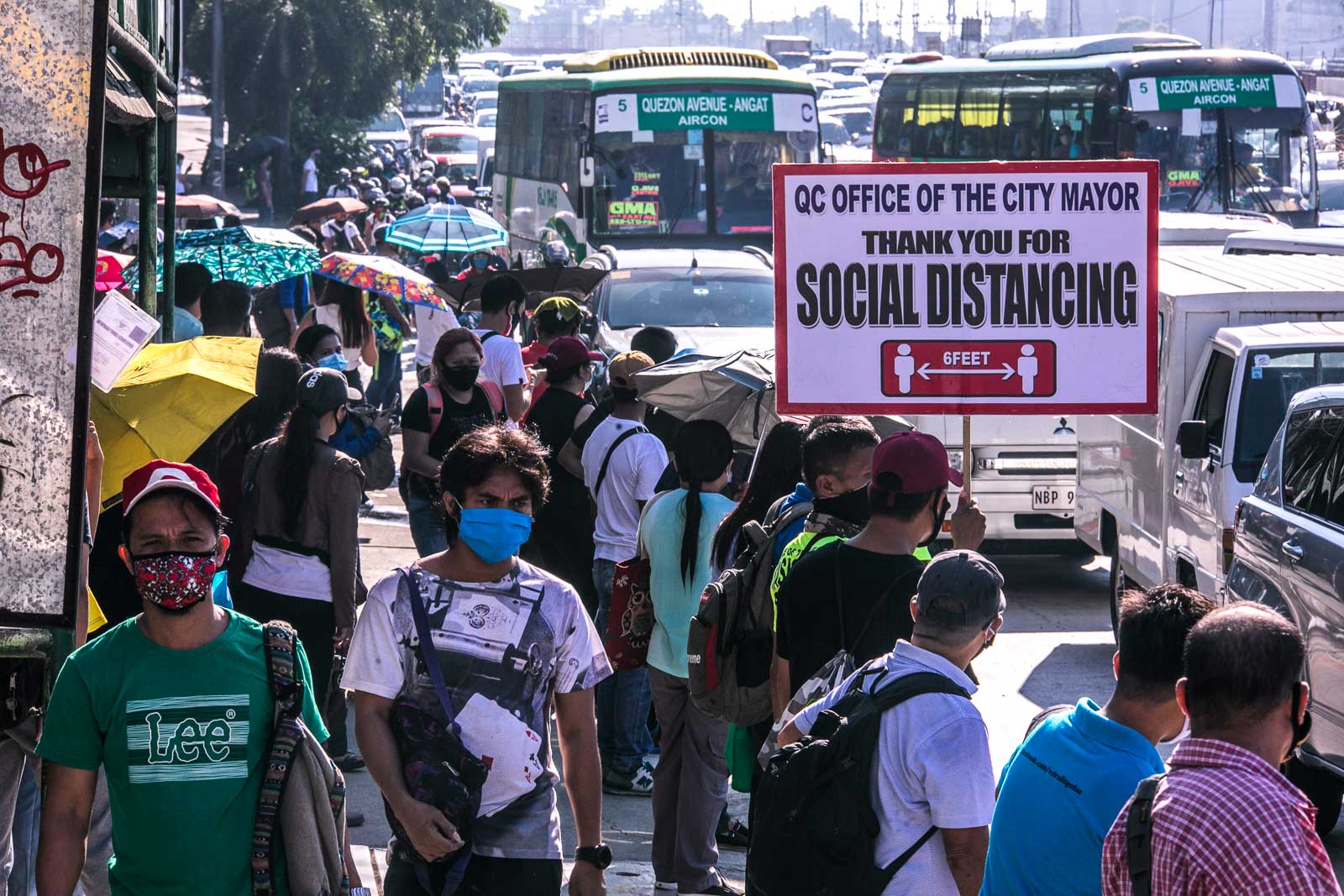 HEALTH PROTOCOLS. Traffic enforcers remind commuters along Commonwealth Avenue, QC to practice physical distancing, during the morning rush hour on Monday, June 22, 2020. Photo by Darren Langit/Rappler 