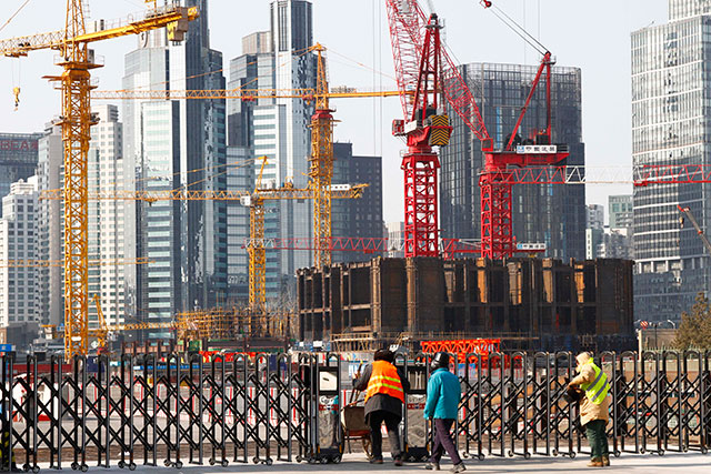 Chinese workers enter a compound of a construction site in Beijing, China, January 28, 2015. Despite a slowdown in economic growth to 7.4% in 2014 and an economic growth forecast of 6.8% issued by the International Monetary Fund for 2015, China is looking to create some 10 million new jobs in 2015 as part of measures for economic stability. EPA / ROLEX DELA PENA