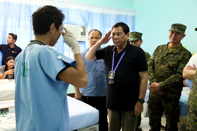 SILENCE THE GUNS. President Rodrigo Duterte salutes a soldier wounded during an encounter with the New People's Army. Malacañang file photo 