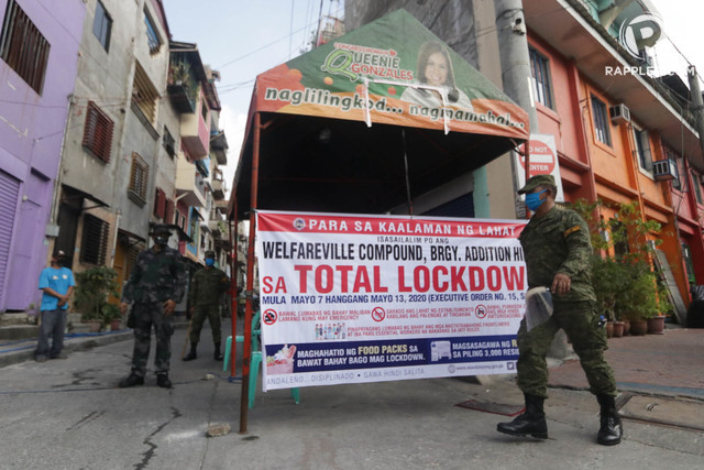 NEW MEASURES. Policemen enforce a 'total lockdown' in a Mandaluyong village with coronavirus cases. Photo by KD Madrilejos / Rappler 