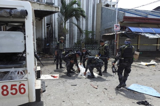 TROUBLED ISLANDS. Philippine security personnel carry a body bag containing the remains of a blast victim after two bombs exploded at the cathedral in Jolo, Sulu, on January 27, 2019. Photo by Nickee Butlangan/AFP 