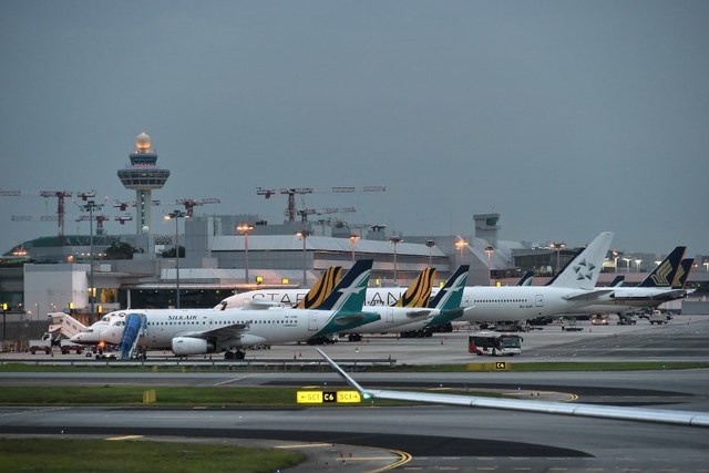 A commercial airplane parked on the tarmac at an international airport.