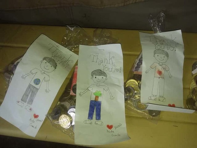 THANK YOU. A girl named Yesha Camille gives some cash and drawings to Flores and the rest of the men who collect their garbage in Quezon City. Photo courtesy of Flores   