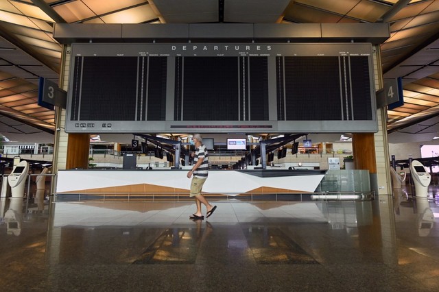 AVIATION SECTOR. A man in a face mask walks past a blank screen on April 30, 2020, in the departure lounge of Terminal 2 at Singapore Changi Airport, which will suspend operations for 18 months from May 1, 2020. , as the COVID-19 pandemic impacts The aviation sector in Singapore. Photo by Roslan Rahman / AFP  