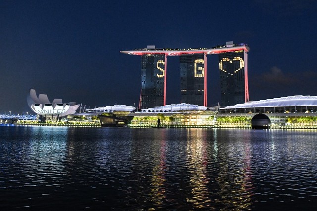 SG UNITED. The letters and the SG Love symbol illuminate the facade of Marina Bay Sands on April 10, 2020, as a message of hope as Singapore battles COVID-19. Photo by Roslan Rahman / AFP 