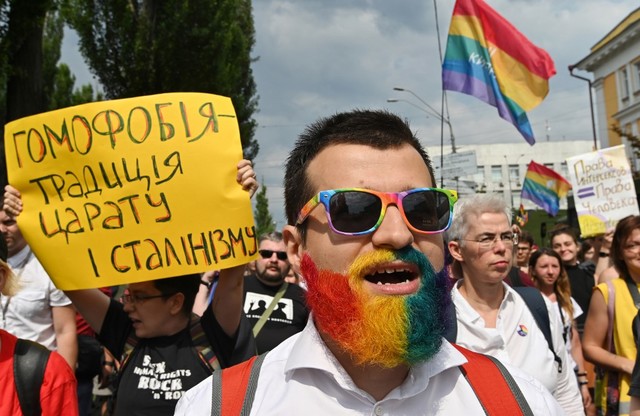 PRIDE. A participant with his beard painted in the rainbow flag colours chants slogans as another holds a placard reading "Homophobia is a Stalin-era tradition" (L), during the annual Gay Pride parade in Kiev, on June 23, 2019. Photo by Genya Savilov/AFP 